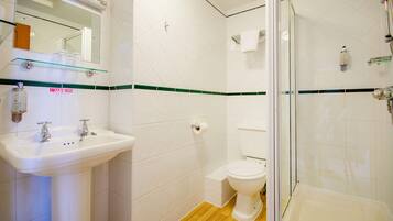 A bathroom with a sink, toilet, and glass-enclosed shower.