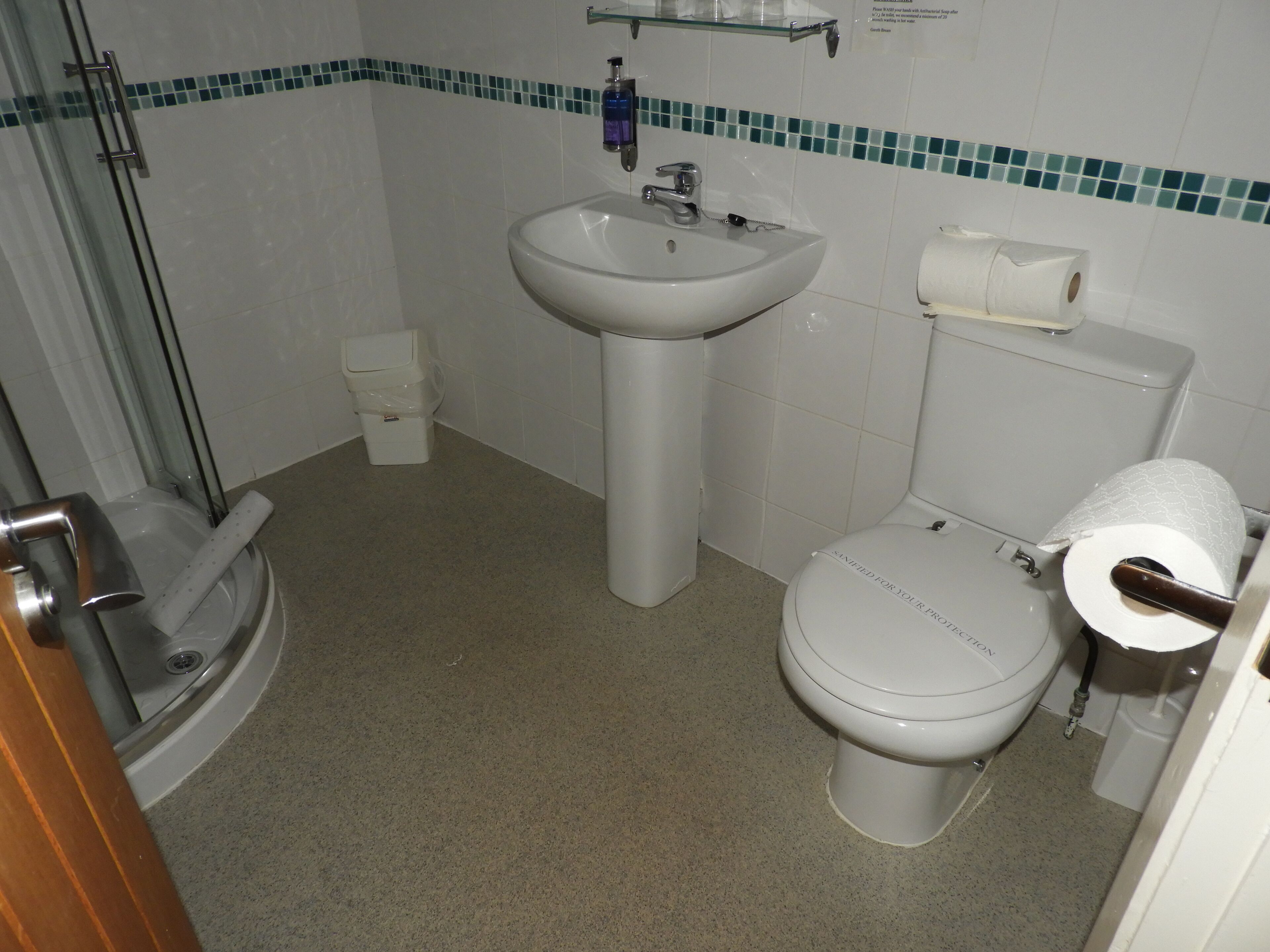 A bathroom with a sink, toilet, and shower.
