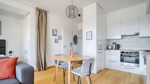 A modern apartment with a dining area, kitchen, and living room.
