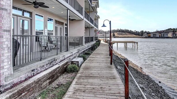 A waterfront hotel with a wooden deck, balconies, and a view of the water. - Homey lakefront condo on quiet cove in Hot Springs (Hot Springs)