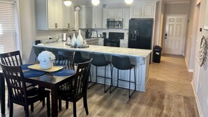 A modern kitchen with white cabinetry, a central island, and pendant lighting. - Homey lakefront condo on quiet cove in Hot Springs (Hot Springs)