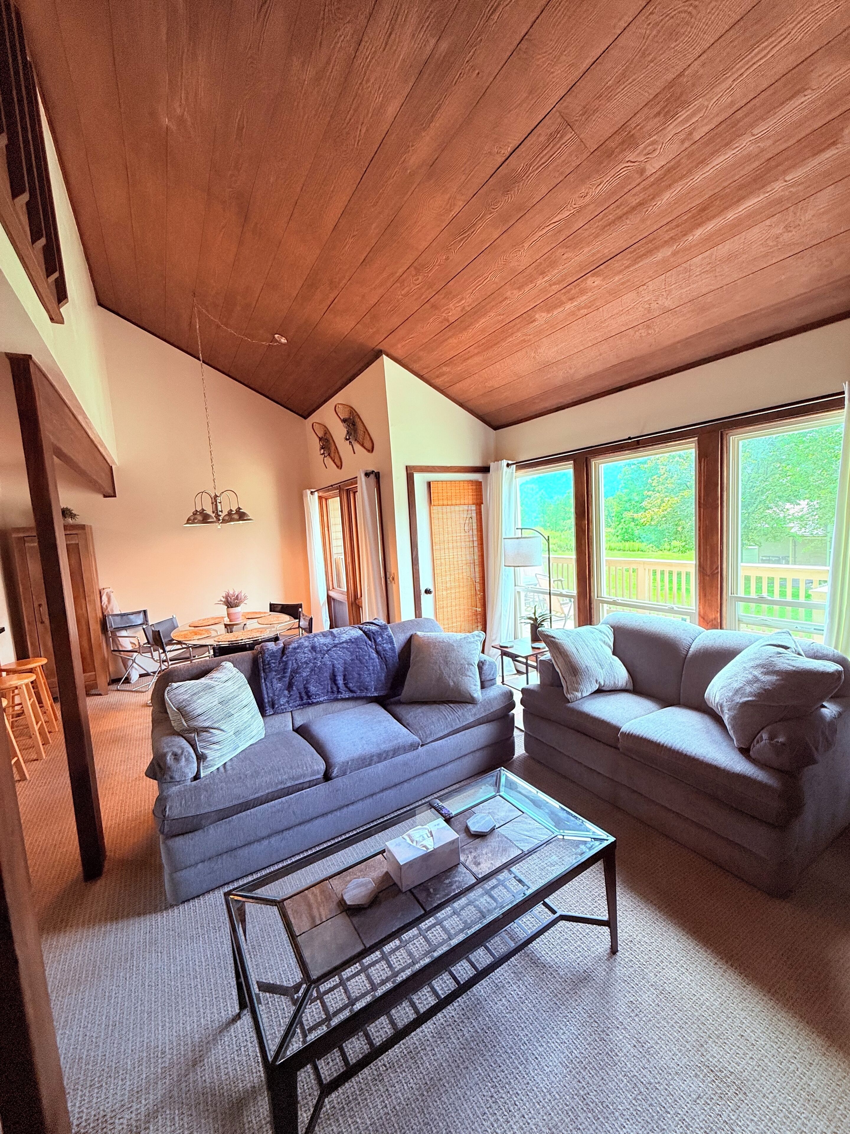 A spacious living room with two sofas, a coffee table, and a dining area with a table and chairs.
