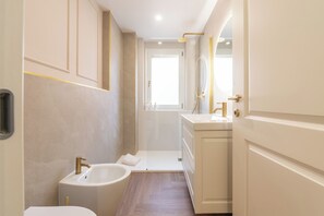 Een douche, een haardroger, een bidet, handdoeken