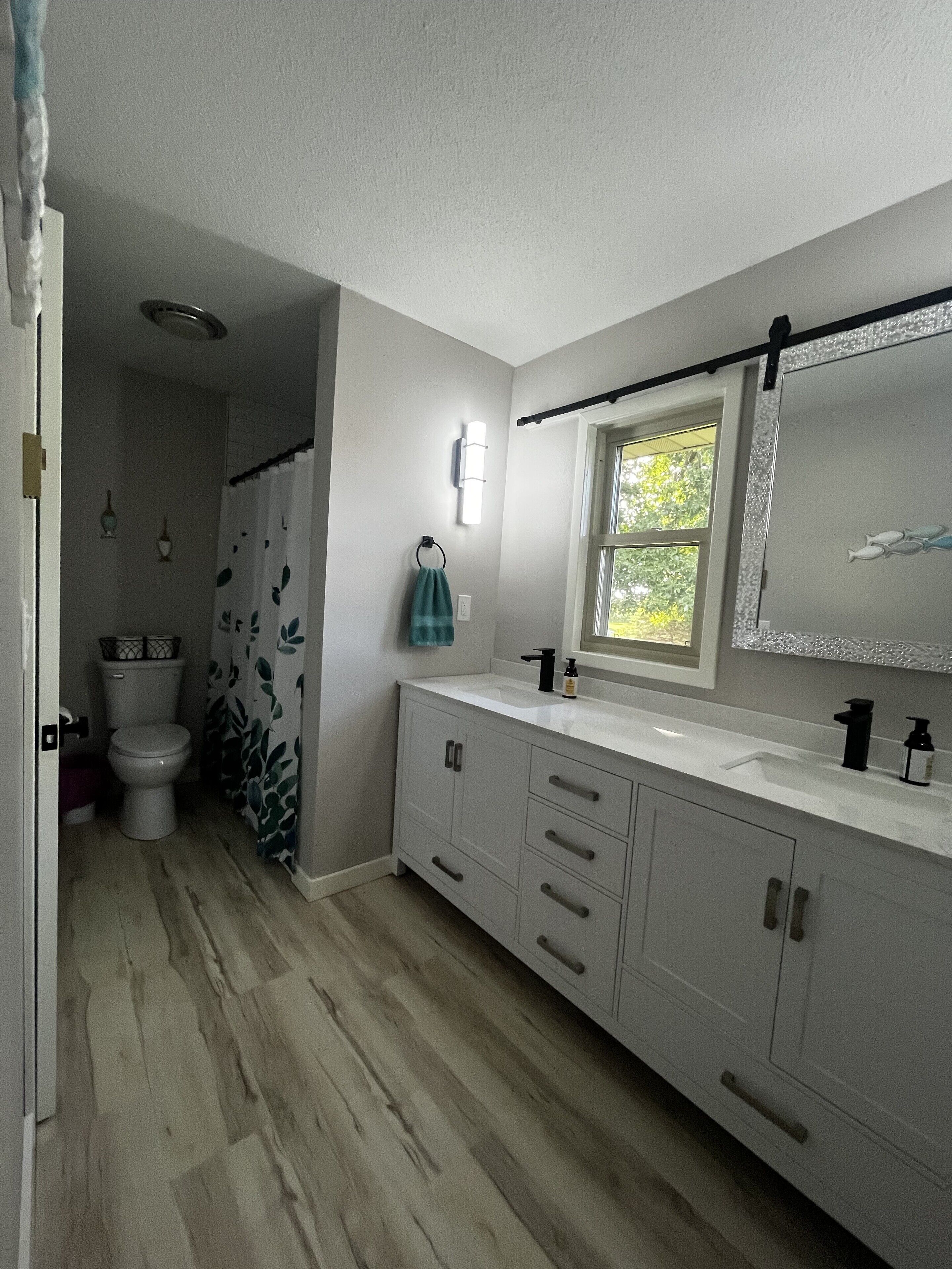 Une salle de bain équipée de toilettes, d’un lavabo et d’un rideau de douche.