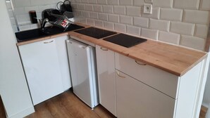 A compact kitchen with white cabinets, a wooden countertop, and a white tiled backsplash. - The black and white nice studio hyper center and wifi (Toulouse)