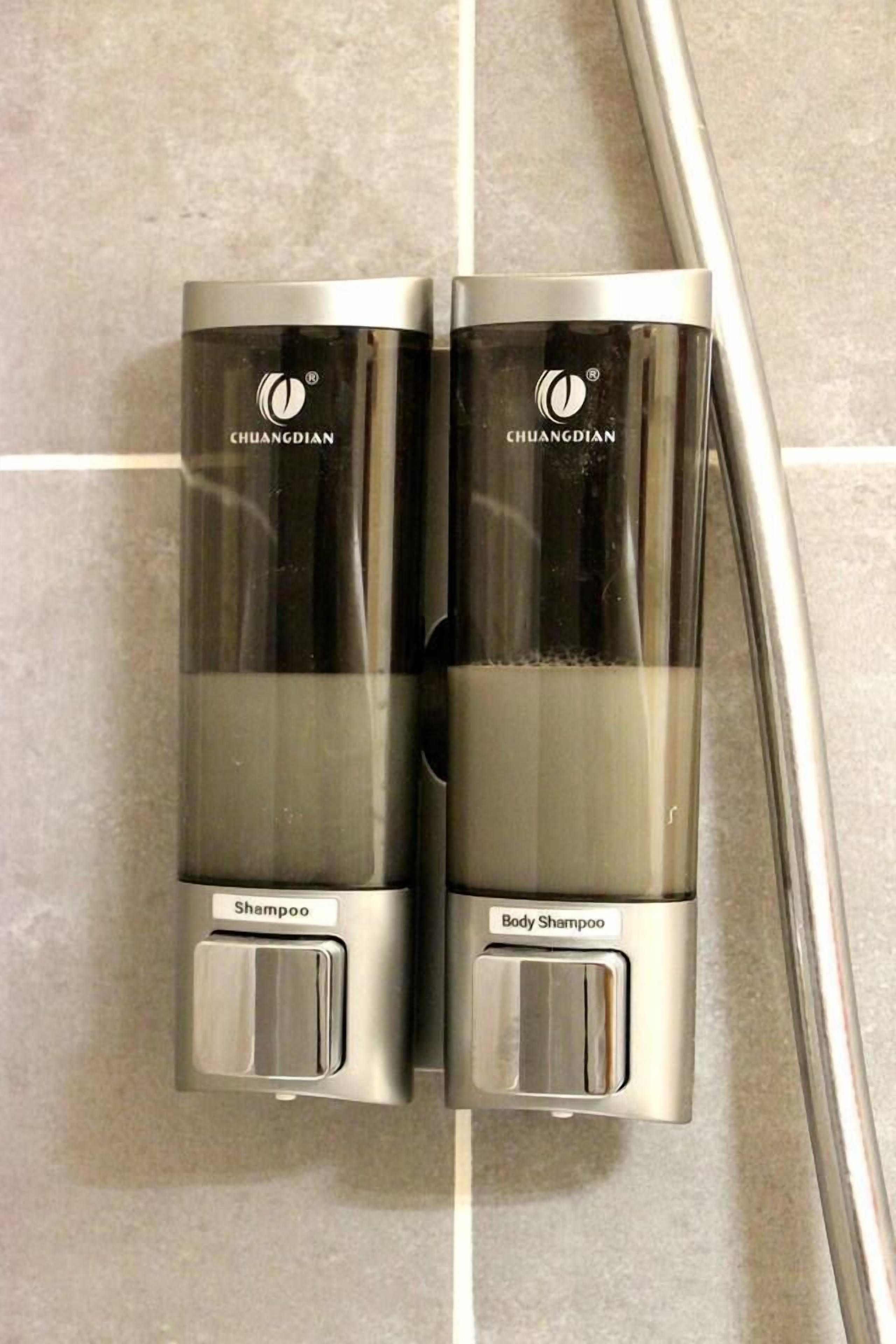 Zwei CHUANGDIAN-Shampoodispenser an einer gefliesten Wand.