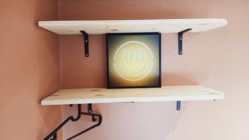 A wall-mounted shelf with a smiley face decoration.