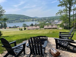A lakeside view with Adirondack chairs and a fire pit. - Sunset Sky Lodge (McHenry)