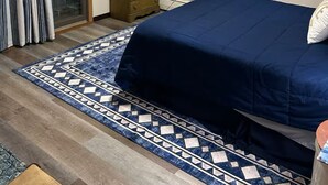 A bedroom with a bed, a dresser, a rug, and a window with curtains. - The Best of Both Worlds – 3 bedroom house with Lake Access Without the Crowds (Mears)