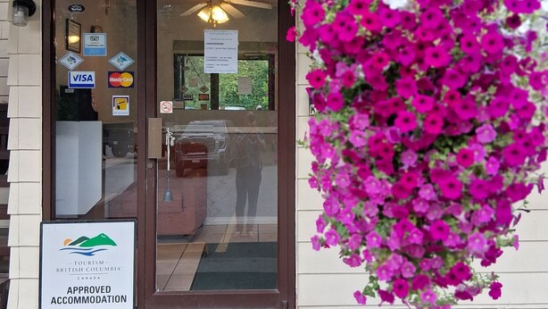 A hotel entrance with a sign indicating approved accommodation by Tourism British Columbia. - Twin Creeks Motel (Lumby)