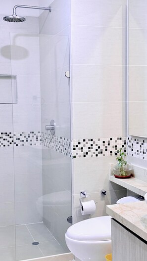 A modern bathroom with a glass shower enclosure, a toilet, a sink with a marble countertop, and a mirror. - Cozy with Sunset View! You'll Love it.Directly owner (Cartagena de Indias)