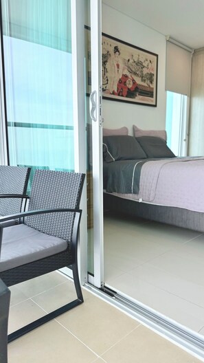 A room with a bed, a chair, and a sliding glass door leading to a balcony. - Cozy with Sunset View! You'll Love it.Directly owner (Cartagena de Indias)