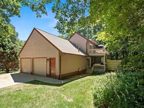 Ein zweistöckiges Haus mit Garage, überdachter Veranda und einem gepflegten Rasen.