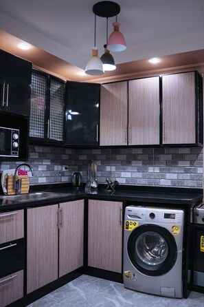 Full-size fridge, microwave, stovetop, cookware/dishes/utensils