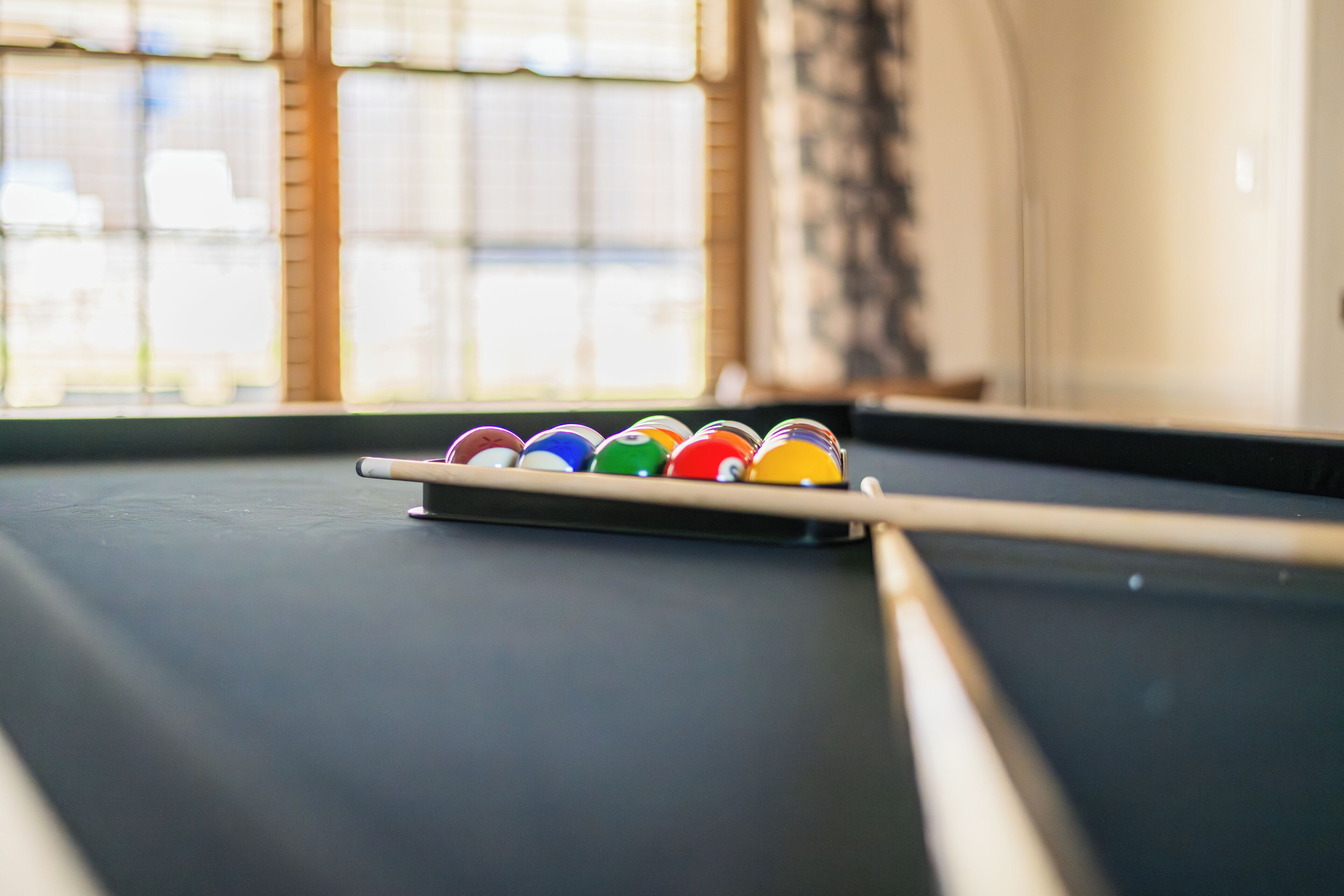 Une table de billard avec un jeu de billes colorées placé au centre.