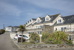 Une rangée de maisons avec une allée pavée et des voitures garées.