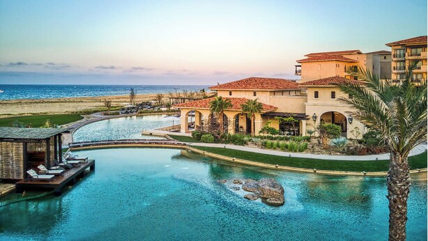 Ein Resort mit Pool, direkt am Strand, und Architektur im mediterranen Stil.