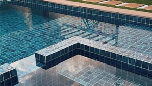 Une piscine dont le fond est carrelé et dont l’eau est claire.