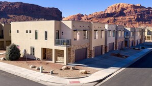 Un immeuble résidentiel moderne à plusieurs étages, doté d’un toit plat, de grandes fenêtres et d’une façade en pierre.