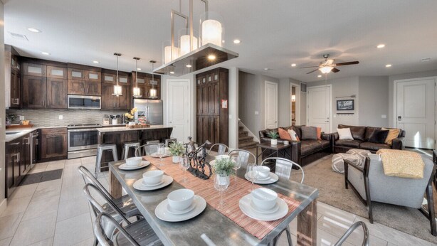 A modern kitchen with dark wood cabinets, stainless steel appliances, and a central island with seating. - Entrada 611 | 4BR Luxury Townhome, Pool, Hot Tub, Garage (Moab)
