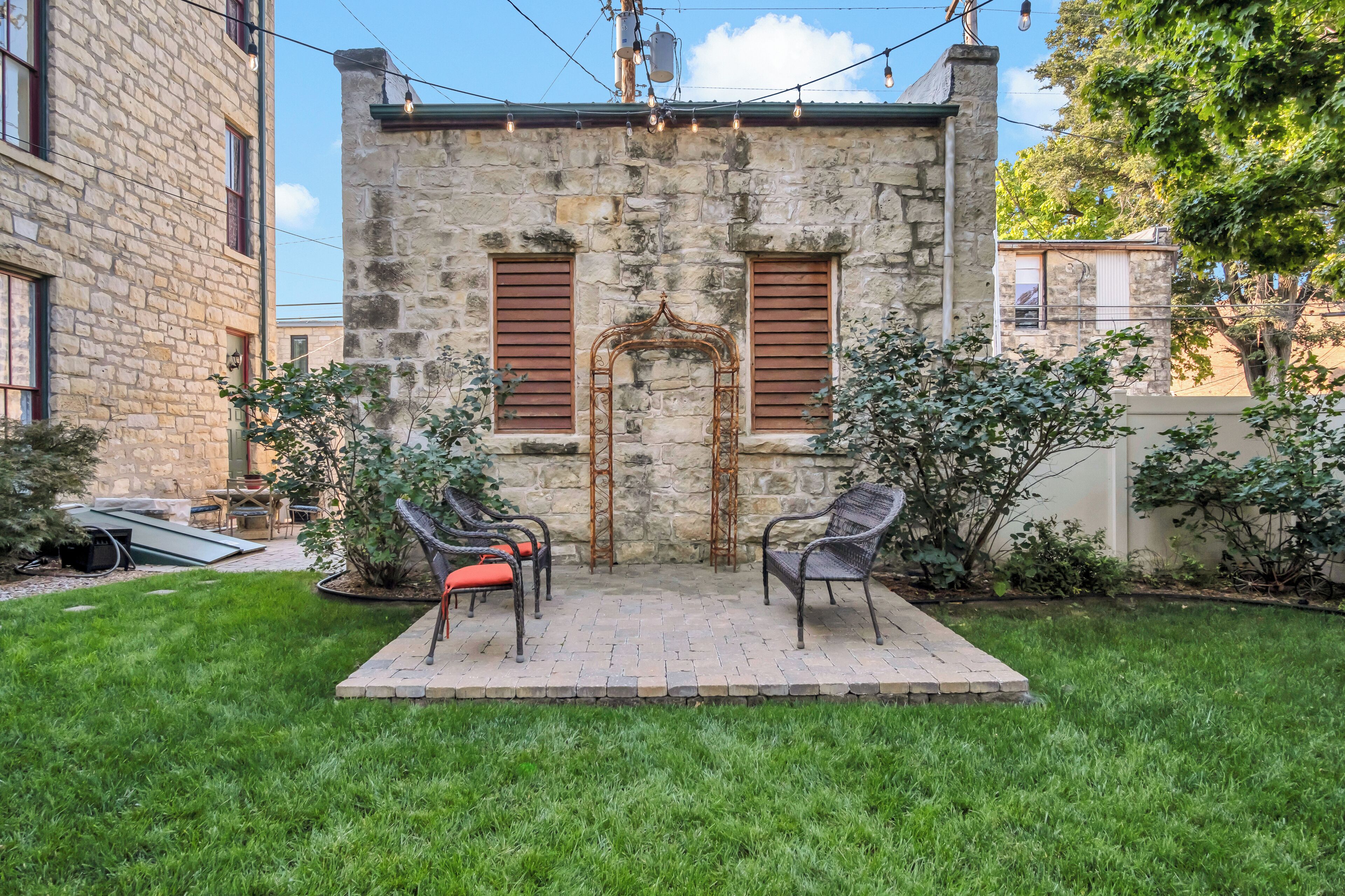A stone building with a small patio area featuring outdoor seating.