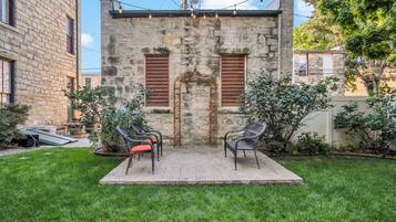 A stone building with a small patio area featuring outdoor seating.