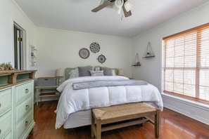 A bedroom with a bed, wooden bench, dresser, and decorative wall art. - Southern Roots Retreat: Spacious Home With Lake Views & Private Boat Launch (Downsville)