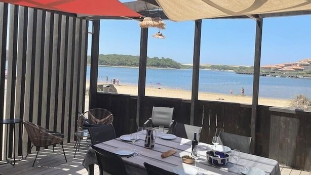 An outdoor dining area with a view of the beach and water.