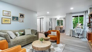 Un salon moderne comprenant un canapé, des fauteuils, une table basse et un coin repas.