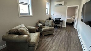 A living room with two sofas, a desk, and a TV. - Downtown Minimalist Apartment (International Falls)