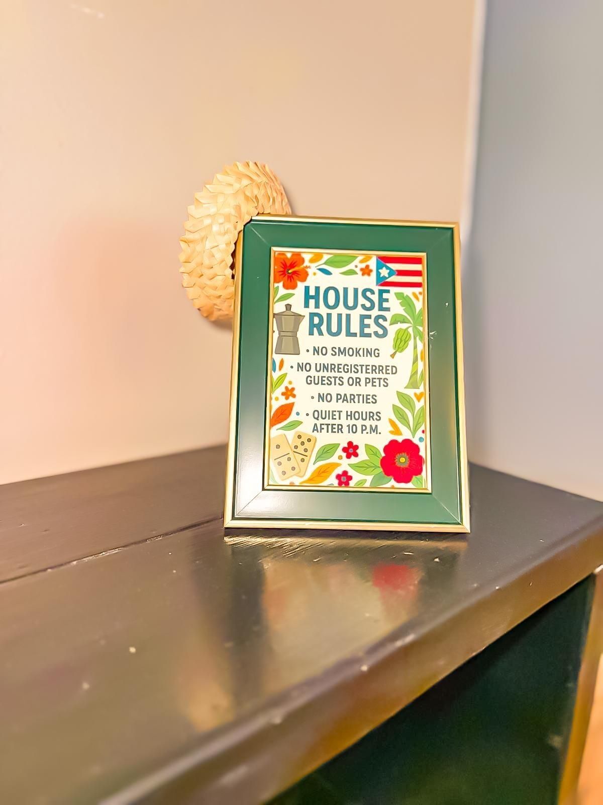 A framed sign with house rules including no smoking, no unregistered guests or pets, no parties, and quiet hours after 10 P.M.