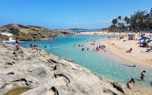 A beach with clear water, rocky areas, and palm trees. - DtMF Experience at his Hometown in Vega Baja - Near Beach and Natural Springs! (Vega Baja)