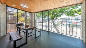 A spacious balcony with a wooden ceiling, a table with benches, and a view of the street. - Barammak-i Pension, Muchangpo, Boryeong (Boryeong)