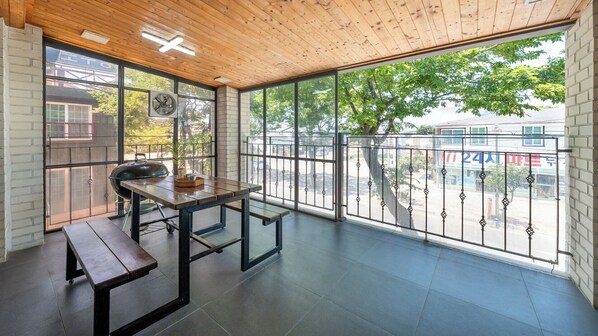 A spacious balcony with a wooden ceiling, a table with benches, and a view of the street. - Barammak-i Pension, Muchangpo, Boryeong (Boryeong)