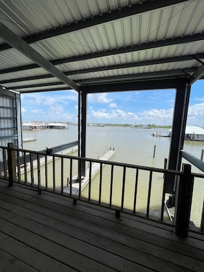 A covered outdoor area with a view of a marina and boats.