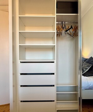 A walk-in closet with multiple shelves and hanging space.