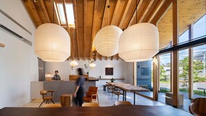 A modern interior with wooden beams, large windows, and a reception desk.