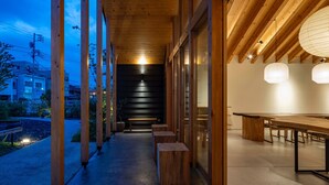A modern building with a wooden interior, large windows, and a long hallway leading to a dining area.