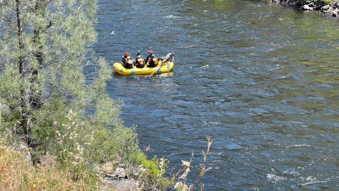 Un grupo de personas en un bote amarillo en un río rodeado de árboles y vegetación.