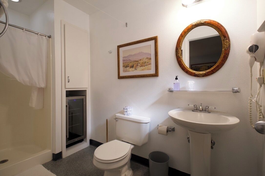A bathroom with a toilet, sink, and shower.