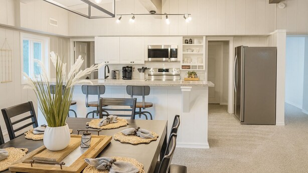 A modern kitchen with white cabinetry, stainless steel appliances, and a central island. - Brookhollow Escape at Ransom Canyon (Ransom Canyon)
