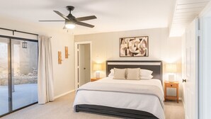 A bedroom with a bed, bedside lamps, a ceiling fan, and a large window. - Brookhollow Escape at Ransom Canyon (Ransom Canyon)