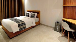 Ein Schlafzimmer mit Bett, Schreibtisch, Stuhl, Deckenventilator und Klimaanlage.