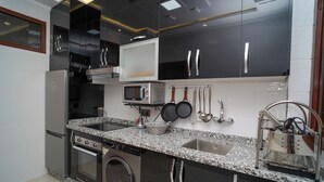 A modern kitchen with stainless steel appliances, a granite countertop, and a built-in oven.