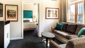 A hotel room with a bed, a sofa, a small table, and a desk. There are framed pictures on the walls and a window with curtains. - Sep 29- Oct 2, Historic Hotel 10 mins from AI Conference 2026, SF 1BR/2BA, (San Francisco)