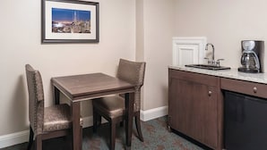 A small kitchenette with a sink, a coffee maker, and a cabinet. There is a framed picture on the wall and a table with two chairs. - Sep 29- Oct 2, Historic Hotel 10 mins from AI Conference 2026, SF 1BR/2BA, (San Francisco)