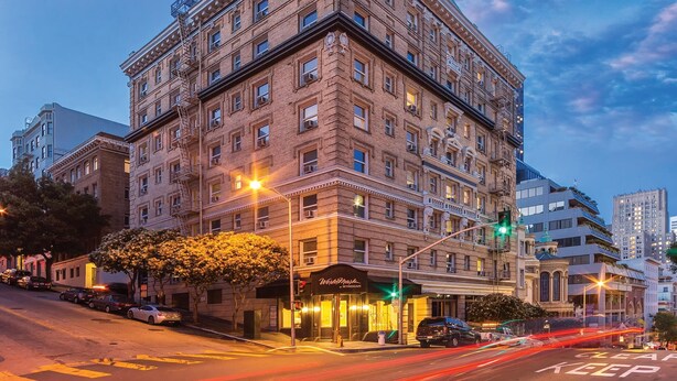 A multi-story hotel with a classic architectural design, featuring a prominent corner entrance and a well-lit facade. - Sep 29- Oct 2, Historic Hotel 10 mins from AI Conference 2026, SF 1BR/2BA, (San Francisco)