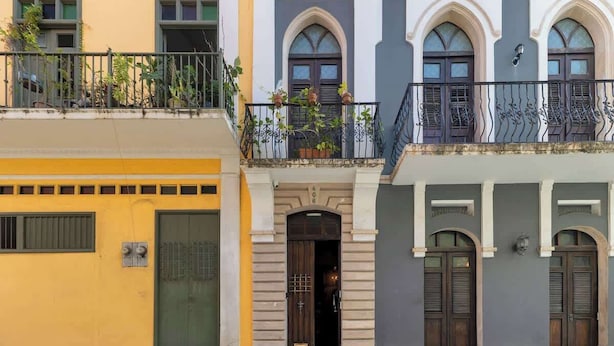 A row of three-story buildings with balconies, arched windows, and a variety of door styles. - Casa Lucienne - Adults Only (San Juan)