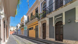 A narrow cobblestone street lined with colorful buildings, each with distinct architectural styles and balconies. - Casa Lucienne - Adults Only (San Juan)