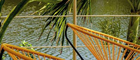 Outdoor seating with a view of a water body and greenery.